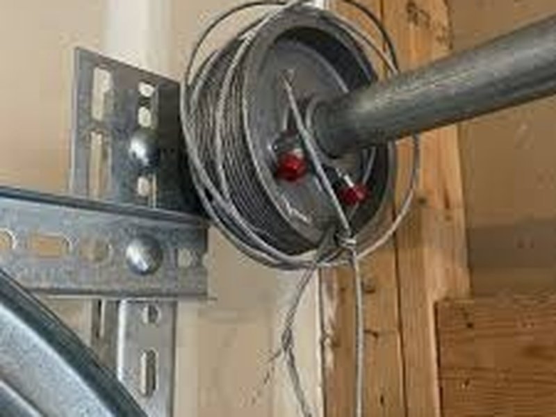 Steel lift cable wound on a drum at the end of a torsion shaft
