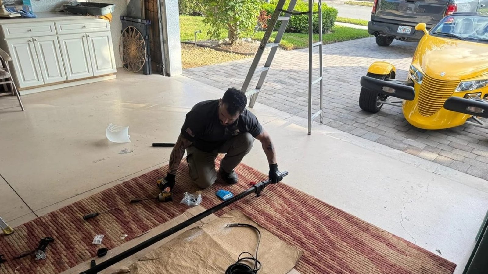 Technician assembling a garage door track on a rug-covered floor